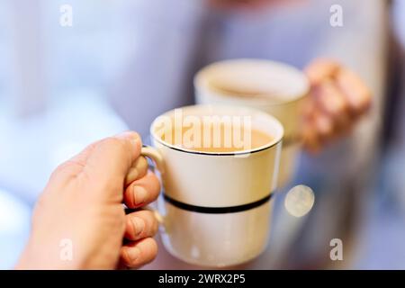 Nahaufnahme eines Paares, das zusammen Tee und Kaffee trinkt Stockfoto