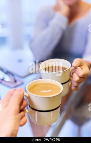 Nahaufnahme eines Paares, das zusammen Tee und Kaffee trinkt Stockfoto