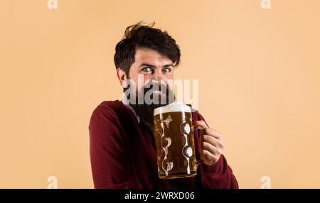 Bierzeit. Oktoberfest fest fest feiern. Glücklicher bärtiger Mann, der Bier in einem Pub oder einer Bar trinkt. Gutaussehender Mann mit schaumigem Bierkrug. Bierverkostung. Lager Stockfoto