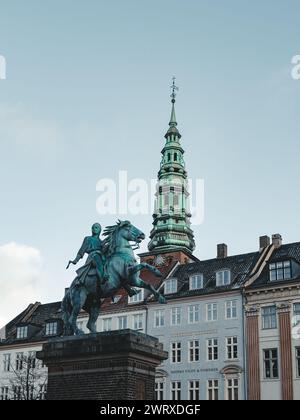 Blick auf den Wahrzeichen grünen Turm der ehemaligen St. Nikolaikirche, heute Nikolaj Zentrum für zeitgenössische Kunst in Kopenhagen, von Hojbro Plads aus gesehen Stockfoto