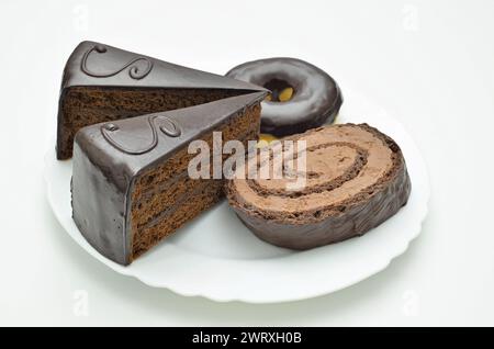 Sacher Torte, Donut und Schokoladentorte auf weißer Platte, Nahaufnahme. Isoliert auf weißem Hintergrund Stockfoto