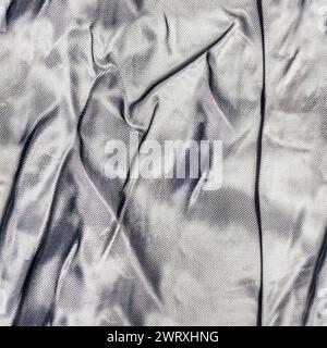 Nahtloses Texturfoto aus grauem, faltigem Seiden- oder Satin-Vorhangmaterial. Stockfoto