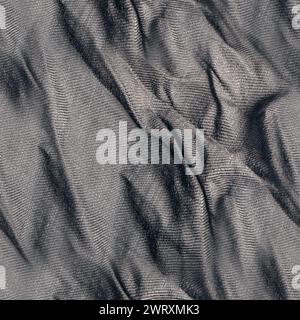 Nahtloses Texturfoto aus grauem, faltigem Baumwoll-Vorhangmaterial. Stockfoto