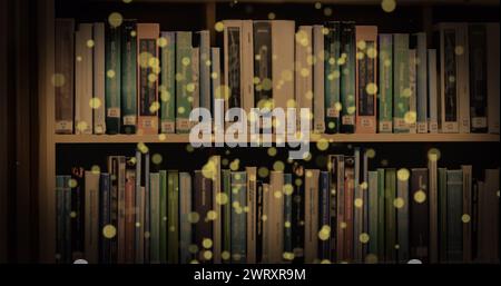 Bild von leuchtenden Flecken über Büchern im Regal Stockfoto