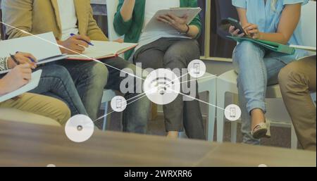 Bild vernetzter Ikonen über verschiedene Frauen, die diskutieren, und Kollegen, die in Notizbüchern schreiben Stockfoto