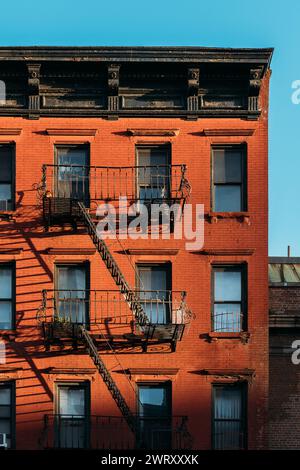 Morgensonne auf dem Red Brick Building mit Eiserfeuer entkommt in New York City Stockfoto