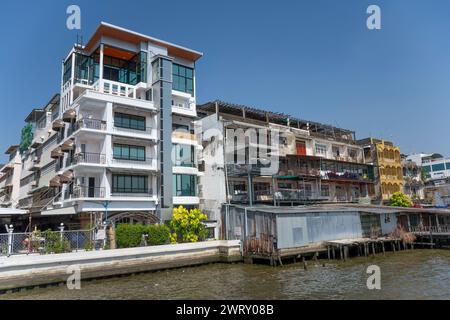 Angrenzende moderne und alte Gebäude am Fluss Chao Phraya, Bangkok, Thailand. Stockfoto