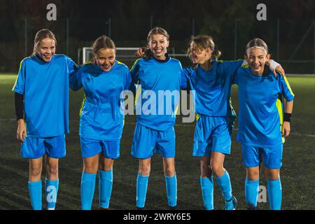 Vollschuss von fünf Mitgliedern des Schulmädchenfußballteams in einem Stadion mit Training, Teamarbeit im Fußball. Hochwertige Fotos Stockfoto