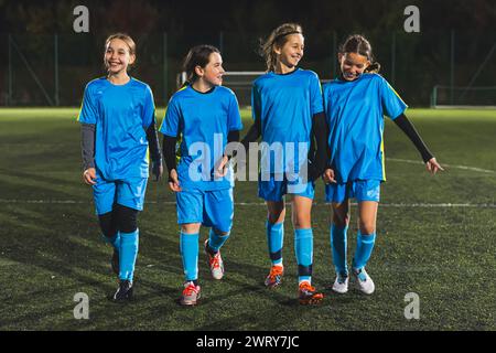 Vier junge Fußballspielerinnen laufen vor dem Training in einem Stadion, voller Schuss. Hochwertige Fotos Stockfoto