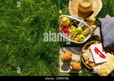 Das Hotel bietet ein romantisches Picknick mit Korb voller leckerer Speisen und Getränke auf dem Gras im Park Stockfoto