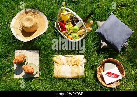 Das Hotel bietet ein romantisches Picknick mit Korb voller leckerer Speisen und Getränke auf dem Gras im Park Stockfoto
