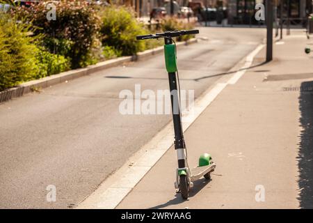 Bild eines französischen Elektrorollers, zur Miete, stehend in einer Straße von lyon, einsatzbereit und über eine App gebucht. Stockfoto