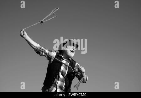 Lasso werfen. Alter Wilder Westen Cowboy mit Seil. Bärtiger Westernmann mit brauner Jacke und Hut, der Pferd oder Kuh fängt. Stockfoto