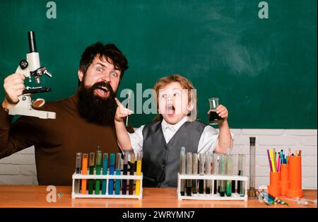 Grundschullehrer und Schüler im Klassenzimmer. Unterrichtspläne - Mittelschulchemie. Kleine Kinder im Schulunterricht. Kindererziehung Stockfoto