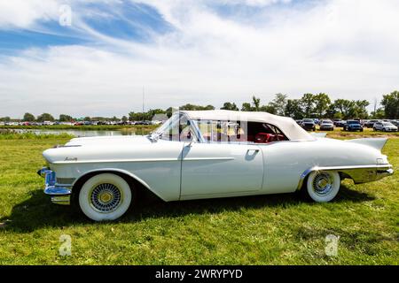 Ein weißes 1957er Cadillac Eldorado Biarritz Cabrio, das im Gras geparkt ist. Stockfoto