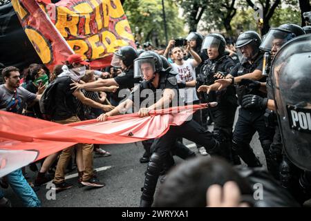 Buenos Aires, Argentinien. März 2024. Ein Polizist zieht die Flagge der Demonstranten. Filmemacher, Fachleute, Studenten und Gruppen des Kollektivs Unidxs por la cultura (Together for Culture) versammelten sich vor dem historischen Gaumont-Kino, um das argentinische Kino zu verteidigen, nachdem die Regierung von Präsident Milei angekündigt hatte, die Mittel für das nationale Institut für Kino und audiovisuelle Kunst (INCAA) zu kürzen. Quelle: Cristina Sille/dpa/Alamy Live News Stockfoto