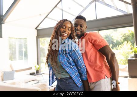 Ein junges afroamerikanisches Paar tanzt zusammen und lächelt zu Hause Stockfoto