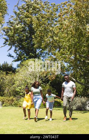 Eine afroamerikanische Familie genießt einen sonnigen Tag im Freien und geht Hand in Hand mit dem Kopierraum Stockfoto