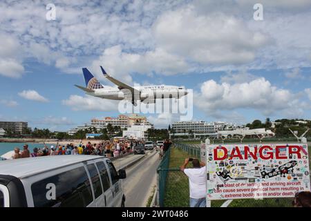 Sint Maarten, Niederlande 26. November 2016: Das Flugzeug landet am Princess Juliana International Airport, vor einer Straße und einem öffentlichen Strand Stockfoto