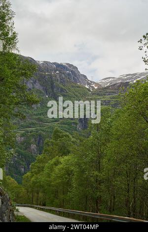 Die dramatisch gewundene Bergstraße mit vielen Serpentinen und Haarnadelkurven hinunter nach Lysebotn im Lysefjorden im gebirgigen Hochland Norwegens. Stockfoto