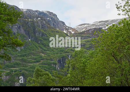 Die dramatisch gewundene Bergstraße mit vielen Serpentinen und Haarnadelkurven hinunter nach Lysebotn im Lysefjorden im gebirgigen Hochland Norwegens. Stockfoto