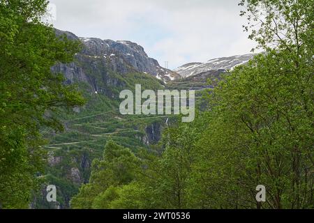 Die dramatisch gewundene Bergstraße mit vielen Serpentinen und Haarnadelkurven hinunter nach Lysebotn im Lysefjorden im gebirgigen Hochland Norwegens. Stockfoto