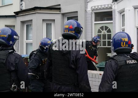 Aktenfoto vom 10/23 von Polizisten der West Midlands Police, die während eines Überfalls der Bezirkslinien in Coventry Zugang zu einem Grundstück erhielten. Acht XL-Bullhunde und mehr als 600 Waffen, darunter Waffen, Nunchucks und Knuckleduster, wurden in einer Woche von Polizeirazzien auf Drogenbanden der Bezirke beschlagnahmt. In der Woche bis zum 10. März wurden im ganzen Land 1.874 Verdächtige verhaftet, wobei 245 Telefonleitungen für Drogenhandel geschlossen wurden. Ausgabedatum: Freitag, 15. März 2024. Stockfoto