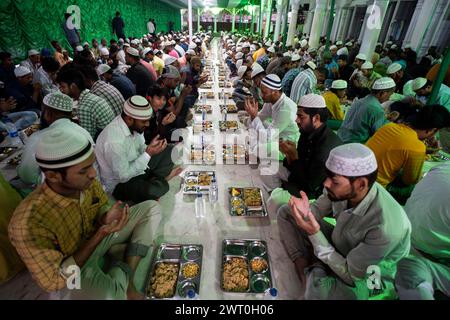 Muslimische Gläubige geben Gebete ab, bevor sie zusammen ein iftar-Essen essen, um ihr Fasten während des heiligen Monats Ramadan in Burha Jame Masjid im März zu brechen Stockfoto