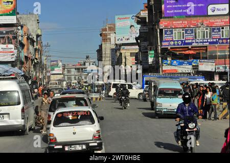 Geschäftige Straßenszene in einer Stadt mit Autos und Motorrädern zwischen Gebäuden mit Werbung, Eindrücken von Nepal, die von Pokhara Valley nach unterwegs sind Stockfoto