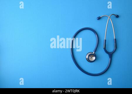 Generischer Gesundheitshintergrund mit Stethoskop isoliert auf blauem Hintergrund. Draufsicht Stockfoto