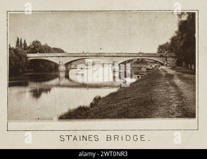 Staines Bridge. Henry W. Taunt, Fotograf (britischer Fotograf, 1842–1922) um 1886 eines von drei Fotos, die eine gedruckte Karte von Laleham, Chertsey und der Umgebung entlang der Themse illustrieren. Das Foto zeigt einen Blick auf die Staines Bridge und einen unbefestigten Schleppweg, der parallel zum Fluss verläuft, auf der rechten Seite des Bildes. (Recto, Mount) unten in der Mitte, unter dem Bild, in schwarzer Tinte gedruckt: „STAINES BRIDGE“. Stockfoto