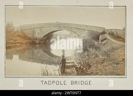 Kaulquetschen-Brücke. Henry W. Taunt, Fotograf (Britisch, 1842 – 1922) 1897 eines von drei Fotos mit Tippeingabe, die eine gedruckte Karte von Duxford und der Umgebung entlang der Themse illustrieren. Das Foto zeigt einen Blick auf die Tadpole Bridge über den Fluss in der Nähe von Faringdon. Ein Mann steht in einem Ruderboot, das im Vordergrund auf dem Fluss schwimmt. (Recto, Mount) unten in der Mitte, unter dem Bild, in schwarzer Tinte gedruckt: „KAULQUETSCHE“ Stockfoto