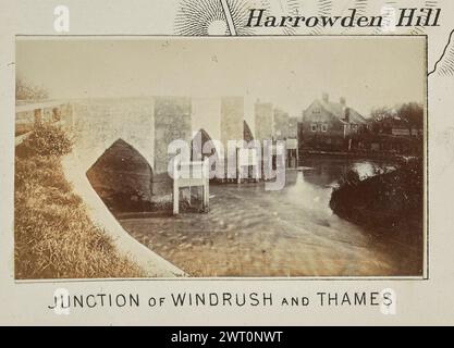 Kreuzung von Windrush und Themse. Henry W. Taunt, Fotograf (Britisch, 1842 – 1922) 1897 eines von drei Fotos mit Tippeingabe, die eine gedruckte Karte von Appleton und der Umgebung entlang der Themse illustrieren. Das Foto zeigt einen Blick auf den Zusammenfluss von Themse und Windrush. Der gewölbte Stein Newbridge kreuzt auf der linken Seite des Bildes, und ein Steingebäude, möglicherweise ein gasthaus, ist auf der anderen Seite der Brücke zu sehen. (Recto, Mount) unten in der Mitte, unter dem Bild, in schwarzer Tinte gedruckt: „JUNCTION OF WINDRUSH AND THAMES“ Stockfoto