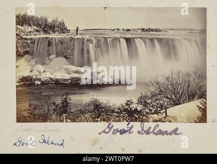 Ziegeninsel. Unbekannt, Fotograf 1860s–1873 Blick auf die Horseshoe Falls, Teil der Niagarafälle, im Winter. Die Terrapin Bridge und der Turm ragt aus Goat Island im oberen linken Bereich des Bildes hervor. Die Felsen am Fuße des Wasserfalls sind mit Schnee und Eiszapfen bedeckt. Schneebedeckte Äste sind im Vordergrund sichtbar. (Recto, Mount) unten links, unten Bild, in Bleistift: 'Ziegeninsel [sic]'; unten links, unten Bild, in blauer Tinte: 'Gov't Island'; unten links, unten Bild, in blauer und lila Tinte: 'Gov't Island'; Stockfoto