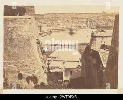 Der Grand Harbour von Fort Lascaris, Valletta. Unbekannt, Fotograf ca. 1864 Ansicht eines Abschnitts eines Hafenbereichs von einem Festungskomplex über dem Wasser. In der Bildmitte ist ein gewölbter Gang sichtbar, der sich über die Breite eines Grabens erstreckt. Stockfoto