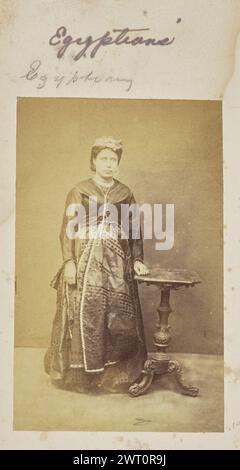 Ägypter. Unbekannt, Fotograf 1861–1903 Porträt einer Frau in einem gemusterten Kleid. Sie legt eine Hand auf einen kleinen Tisch neben sich. (Recto, Mount) oben links, oben auf dem Bild, in lila Tinte: 'Ägypter'; oben links, oben auf dem Bild, in Bleistift: 'Ägypter'; Stockfoto