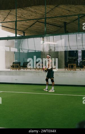 Mann spielt Padel-Tennis auf einem Hallenplatz, Bali. Stockfoto