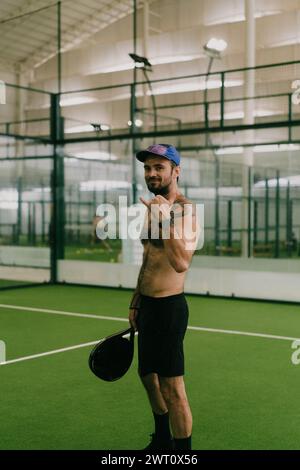 Mann spielt Padel-Tennis auf einem Hallenplatz, Bali. Stockfoto