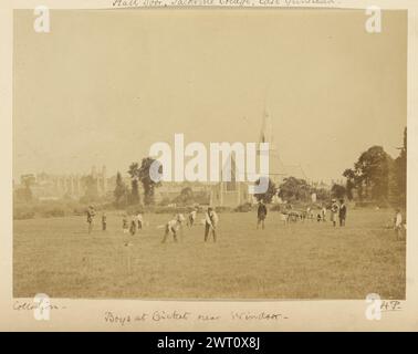 Jungs im Cricket bei Windsor. Henry Pollock, Fotograf (britischer Fotograf, 1826–1889) 1854–1856 Eine Gruppe von Jungen spielt Cricket auf einer Wiese vor einer Kirche. Ein Wagen sitzt auf dem Feld mit Eltern in der Nähe. Die Eton College Chapel ist in der Ferne sichtbar. (Recto, Mount) unten rechts, unten Bild, in schwarzer Tinte: 'Collodion-': Unten Mitte, unten Bild, in schwarzer Tinte: 'Jungs bei Cricket in der Nähe von Windsor-'; unten rechts, in schwarzer Tinte: 'HP-' [unterstrichen]; (Verso, Mount) unten links, Bleistift: 'A15.62'; Stockfoto