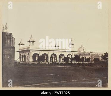 Die Diwan-i-Khas im Roten Fort von Delhi. Unbekannt, Fotograf der 1850er–1890er Jahre Ansicht des Diwan-i-Khas im Roten Fort von Delhi. Das Gebäude verfügt über gewölbte Bögen, detaillierte Intarsien und vier Chhatri oder Kuppelpavillons an den Ecken des Daches. Ein Mann ruht auf einer Leiter, die sich an der linken Seite des Gebäudes, möglicherweise zur Reinigung oder Reparatur, in der Nähe von zwei Pferdekutschen anlehnt. Ein schmiedeeiserner Zaun führt am Diwan-i-Khas vorbei und trennt ihn vom grasbewachsenen Rasen im Vordergrund. Die Kuppel des Khas Mahal ist hinter dem Pavillon auf der rechten Seite des Bildes sichtbar. Stockfoto