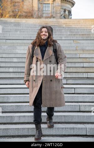 Junger gutaussehender Kerl mit langen dunklen Haaren Stockfoto