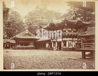 Yōmeimon-Tor am Nikkō Tōshō-gū-Schrein. Unbekannt, Fotograf aus den 1850er–1890er Jahren Blick auf das Yomeimon-Tor und die umliegenden Gebäude, vom Innenhof aus, am Nikko Tosho-gu-Schrein. Ein Korridor erstreckt sich vom Tor aus und führt in Richtung Kagura-den. Das Tor ist mit aufwendigen und detaillierten Schnitzereien und Relieffiguren verziert. Stockfoto