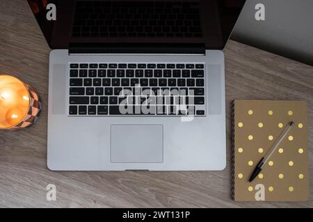 Einfacher Arbeitsplatz zu Hause mit Laptop, Kerze und Notebook Stockfoto