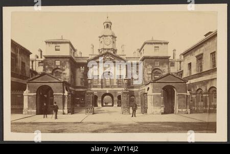 Horse Guards, London. Unbekannt, Fotograf um 1880–1895 Ein großes Gebäude mit einem Uhrturm in der Mitte. Vor dem Gebäude befinden sich zwei Wachhäuser, die sich gegenüber der Straße befinden. Zwei Männer mit Kopfbedeckung stehen vor einem der Wachhäuser. Ein Polizist in Uniform steht auf dem Gehweg von den Männern, näher am anderen Wachhaus. (Verso, Mount) Mitte, Bleistift: 'Horse GDS./St James PL. Lond"; Stockfoto