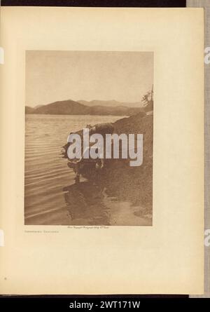 Sammeln Von Algen. Edward S. Curtis, Fotograf (amerikanisch, 1868–1952) Negativdruck 1915 1916 Eine Person in Bastkleidung, die am Wasserrand steht und sich verbeugt, um Algen zu sammeln. Stockfoto