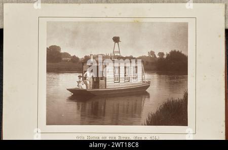Unser Haus am Fluss. Henry W. Taunt, Fotograf (britischer Fotograf, 1842–1922) um 1886 Ansicht von Henry Taunts Boot auf der Themse. Spount steht neben dem Bug des Bootes, lehnt sich an den Türrahmen, mit gefalteten Armen hinter seinem Rücken. Eine Frau, möglicherweise seine Assistentin und Ladenleiterin Fanny Miles, sitzt seitlich auf einem Stuhl am Bug des Bootes, mit den Armen über der Rückseite des Stuhls. Zwei Schilder zieren das Boot mit dem Namen Spount, und seine Kamera ist auf dem Dach des Bootes zu sehen. (Recto, Mount) unten in der Mitte, unter dem Bild, gedruckt in verblasster schwarzer Tinte: „OUR HOU Stockfoto