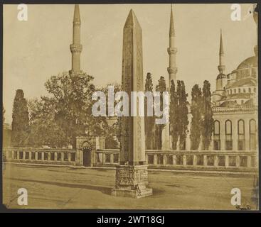 Obelisk von Theodosius. Durand, Fotograf (französisch, Mitte des 19. Jahrhunderts aktiv), etwa 1850–1860 Mann, der auf der Basis eines ägyptischen Obelisken in der Mitte der Straße sitzt. Die Minarette der Blauen Moschee (Sultan-Ahmed-Moschee) stehen hinter ihm. Stockfoto