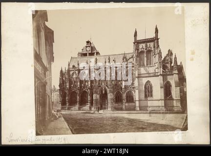 Kirche Notre-Dame de Louviers. Unbekannt, Fotograf 1859 Seitenansicht einer gotischen Kathedrale, gesehen von einer gekrümmten Straße. Die Seitenfassade des Gebäudes hat Reihen von Spitzbögen und mehrere kleine Türme. Zwei Männer stehen vor dem Eingang an der Seite der Kathedrale. (Recto, Mount) oben rechts, Bleistift: '19'; unten links, Bleistift: 'Louviers église ppale 1859'; unten rechts, Bleistift: 'à Louviers église prinzipale 1859'; (rückseitig, Mount) unten links, Bleistift: '7'; Stockfoto