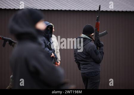 Ukrainische Frau hält ein Kalaschnikow-Gewehr auf einem militärischen Trainingsplatz. Kiew - 27. Januar 2024 Stockfoto