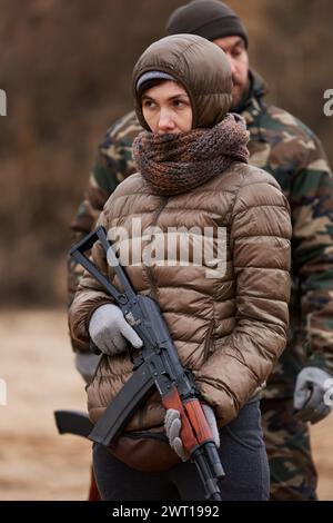 Ukrainische Frau hält ein AK-Gewehr auf einem Trainingsgelände. Kiew - 27. Januar 2024 Stockfoto